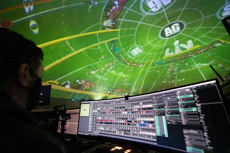 Operator at a media server screen as a football field graphic with a Super Bowl LV logo fills the Atlanta projection dome