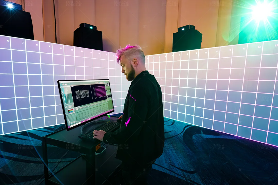 Technician at a computer calibrating a grid test pattern in a 360-degree projection room at the BITMAIN WDMS booth