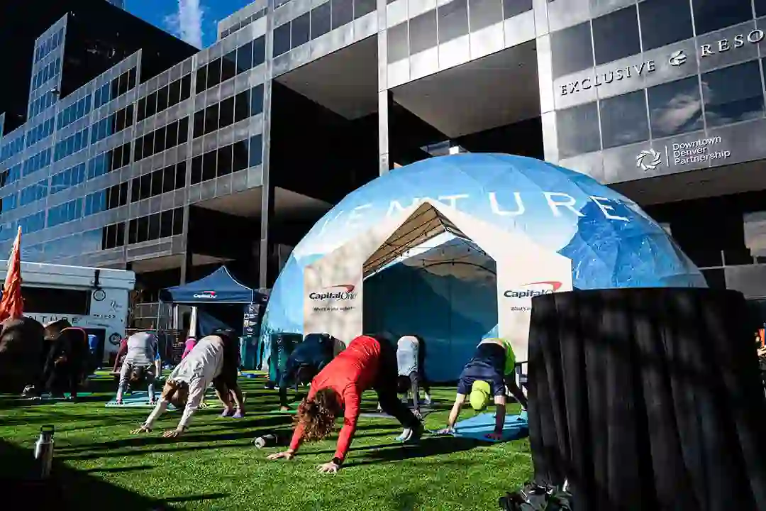 Capital One Venture dome in downtown Denver with people doing yoga on artificial turf in front of it