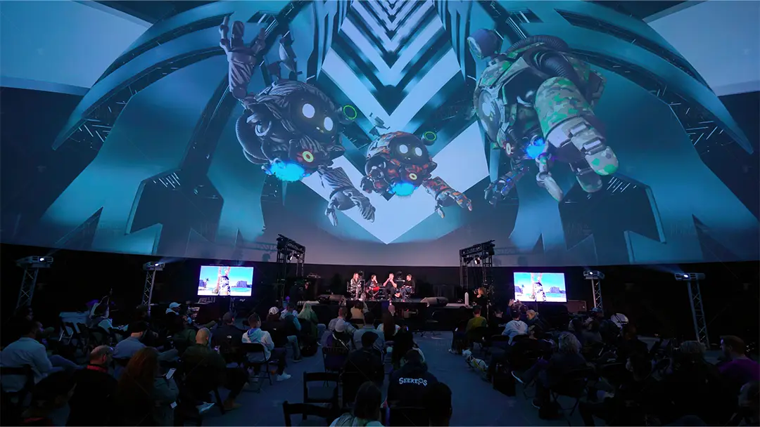 Panel on stage inside a projection dome at SXSW, with giant robot artwork projected overhead and a seated audience