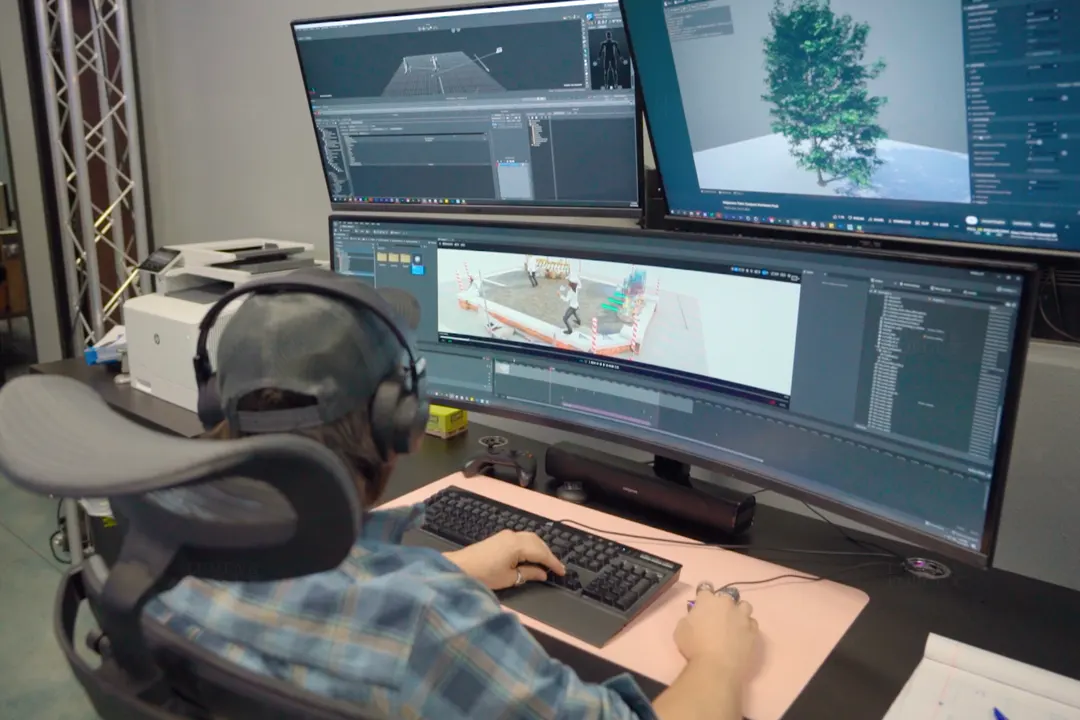 Animator in headphones editing a 3D scene on a curved monitor at the Lumen and Forge studio