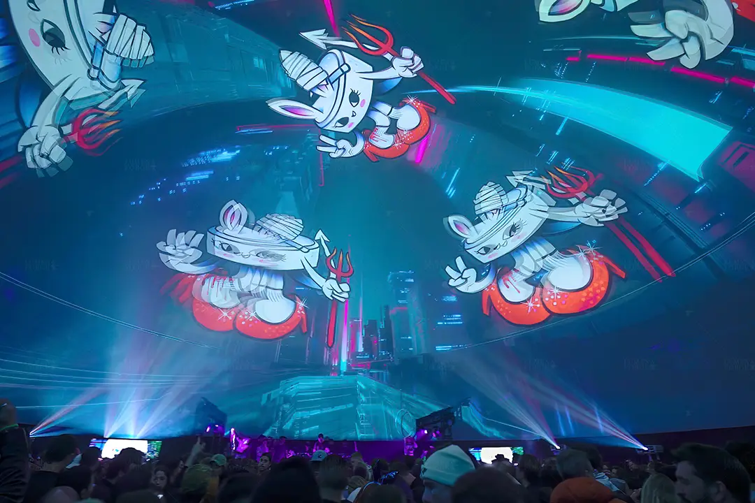 Crowd under the SXSW immersive dome with cartoon rabbit characters and light beams projected overhead