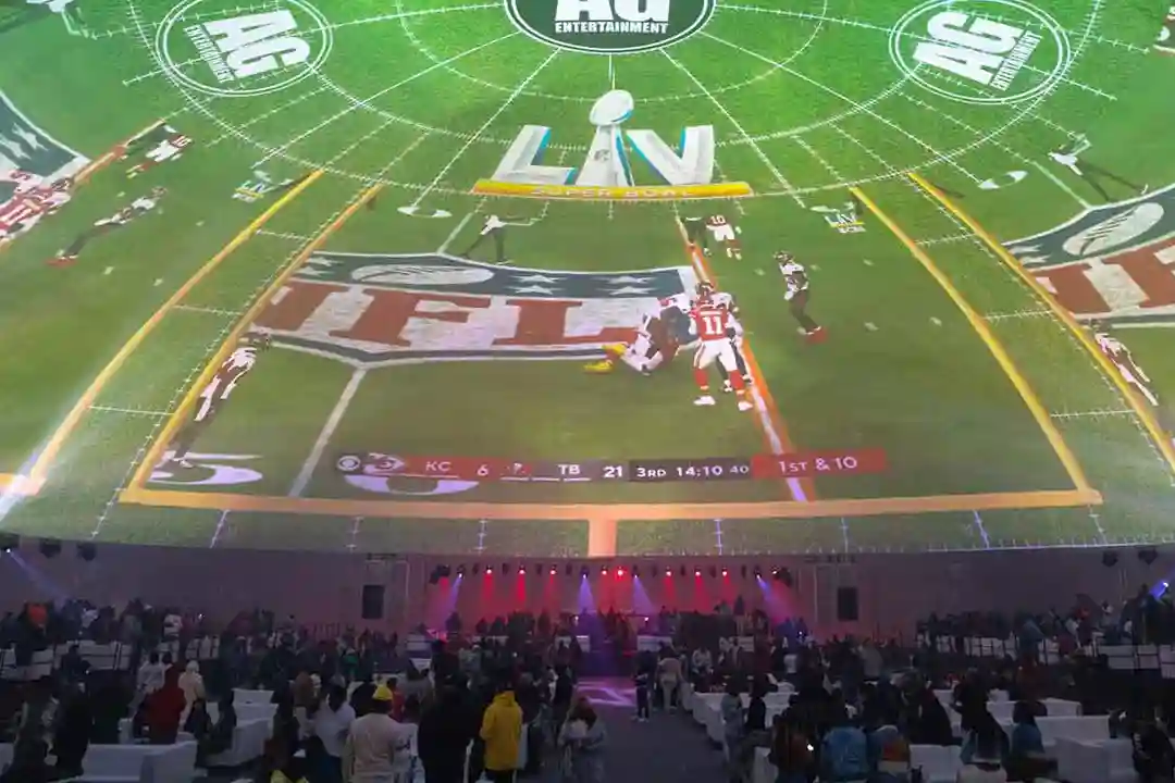 Guests seated inside The Dome beneath a 360-degree football field projection with NFL, Super Bowl LV and AG Entertainment logos