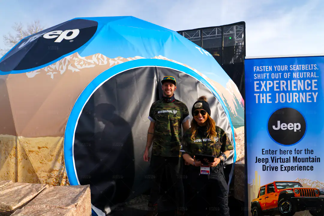 Jeep branded dome with an 'Experience the Journey' banner for the Jeep Virtual Mountain Drive Experience, two people at the entrance