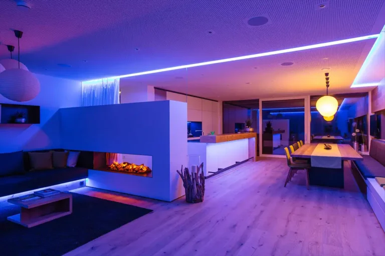 Modern living room with immersive lighting, featuring a sleek linear fireplace and integrated LED lights, creating a vibrant and cozy ambiance.