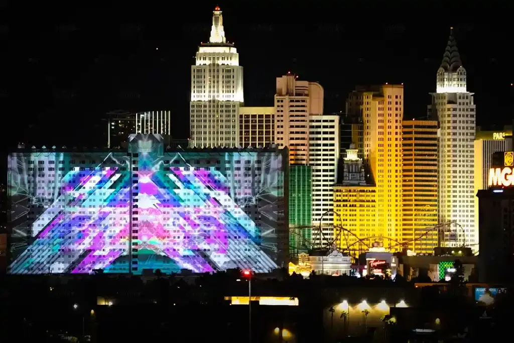 Projection mapping on the Tropicana Las Vegas building, showcasing vibrant geometric visuals against the iconic Las Vegas Strip skyline at night.