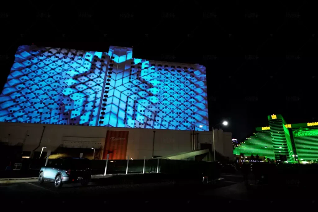 Projection mapping display on the exterior of Tropicana Las Vegas, showcasing intricate blue geometric patterns that transform the building facade into an immersive visual experience at night.